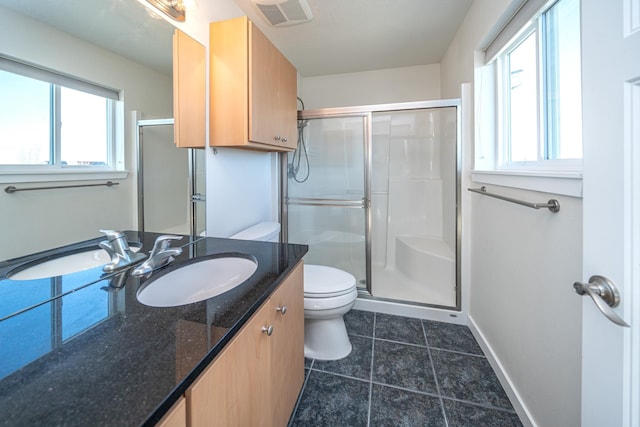 bathroom with tile patterned flooring, vanity, an enclosed shower, and toilet