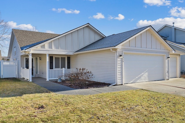 view of front of house with a garage, covered porch, and a front yard