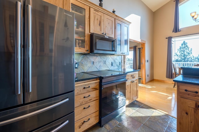 kitchen with dark wood-type flooring, appliances with stainless steel finishes, high vaulted ceiling, and decorative backsplash