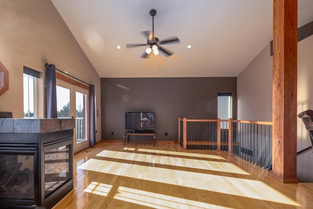 living room featuring lofted ceiling, light hardwood / wood-style floors, and a multi sided fireplace