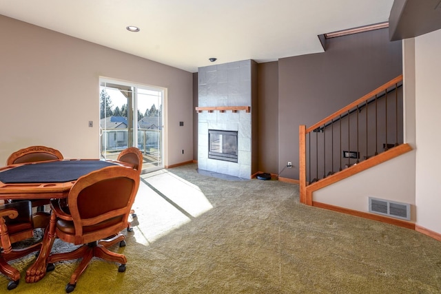 interior space featuring carpet flooring, access to exterior, and a tiled fireplace