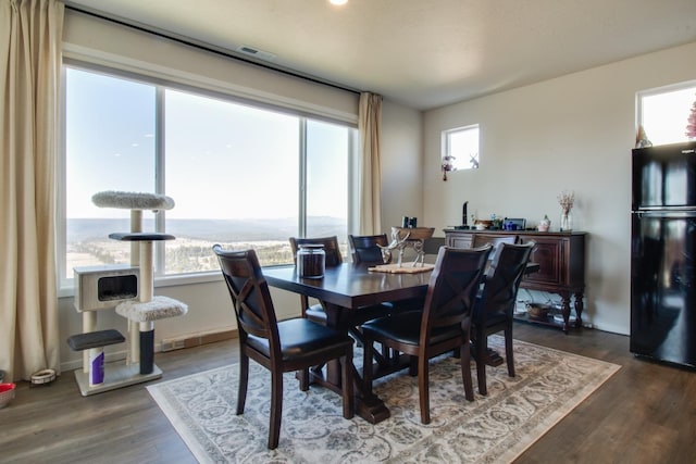 dining room featuring dark wood-type flooring and a water view