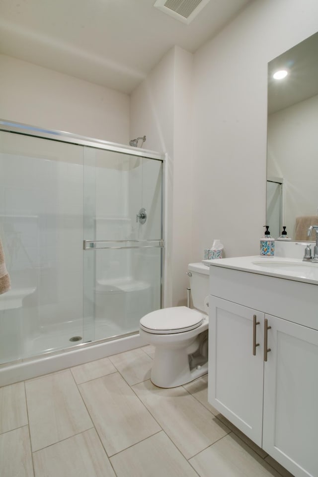 bathroom with walk in shower, vanity, and toilet