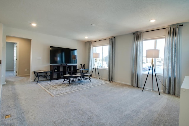 living room featuring light carpet and a textured ceiling