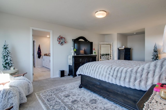 bedroom featuring light carpet and ensuite bathroom