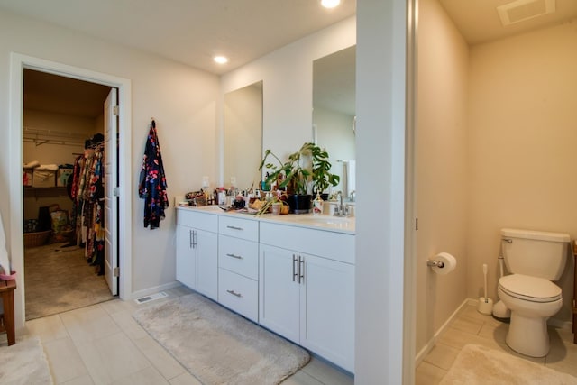 bathroom with tile patterned flooring, vanity, and toilet