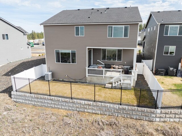 rear view of house with central AC unit