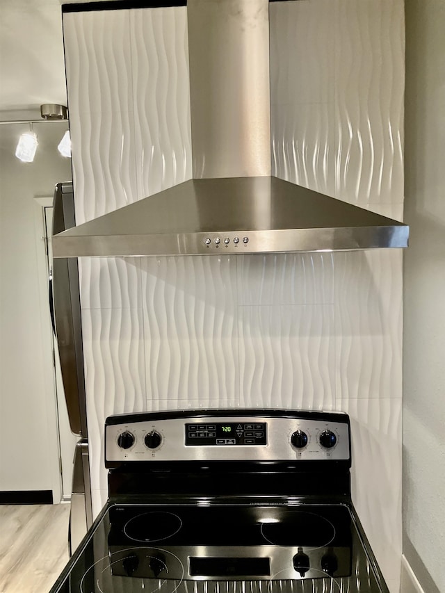 kitchen with wall chimney range hood and electric range