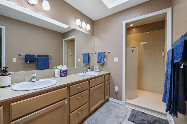 bathroom featuring vanity, a skylight, and a shower