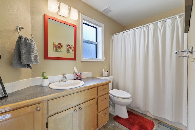 bathroom featuring vanity, curtained shower, and toilet