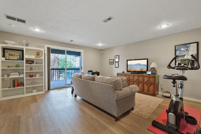 living room with light hardwood / wood-style flooring and a textured ceiling