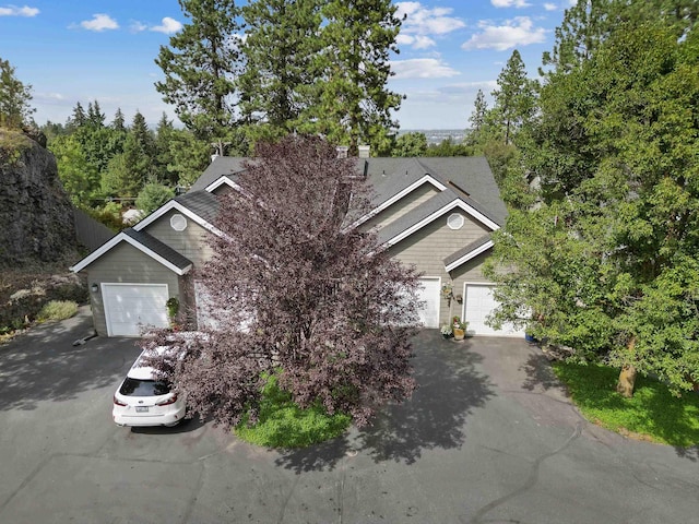 view of property hidden behind natural elements with a garage