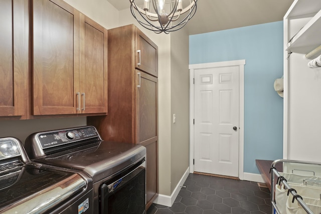 clothes washing area with washer and clothes dryer, a chandelier, dark tile patterned floors, baseboards, and cabinet space