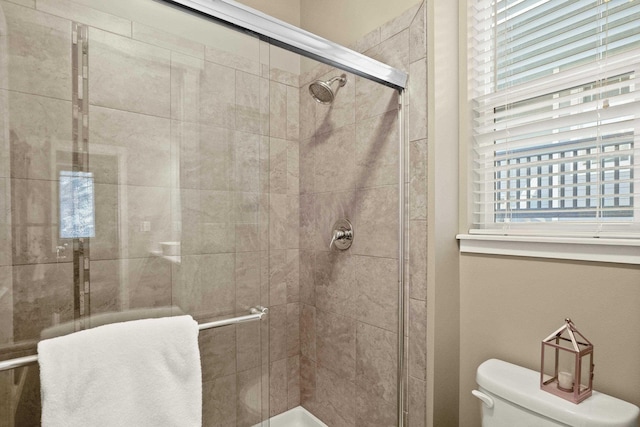 full bathroom with a shower stall and toilet