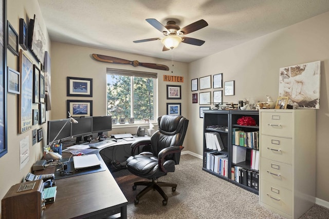 carpeted office with a textured ceiling, baseboards, and a ceiling fan