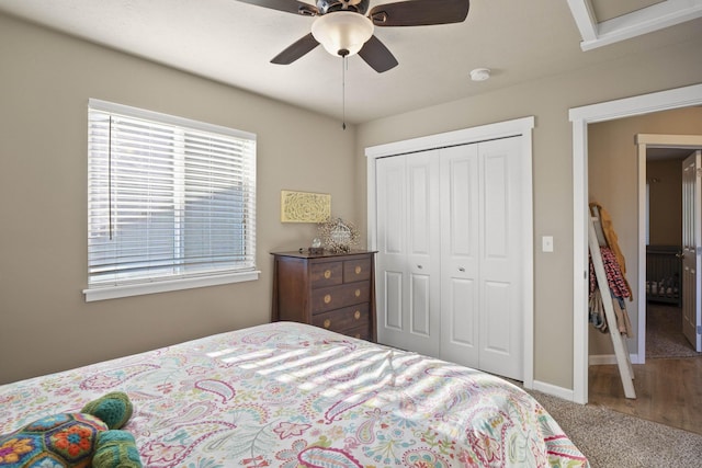 bedroom with a closet, carpet flooring, a ceiling fan, and baseboards