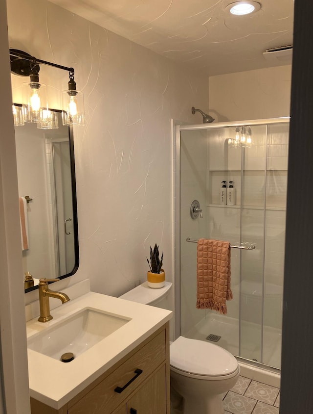 bathroom with toilet, vanity, and a stall shower