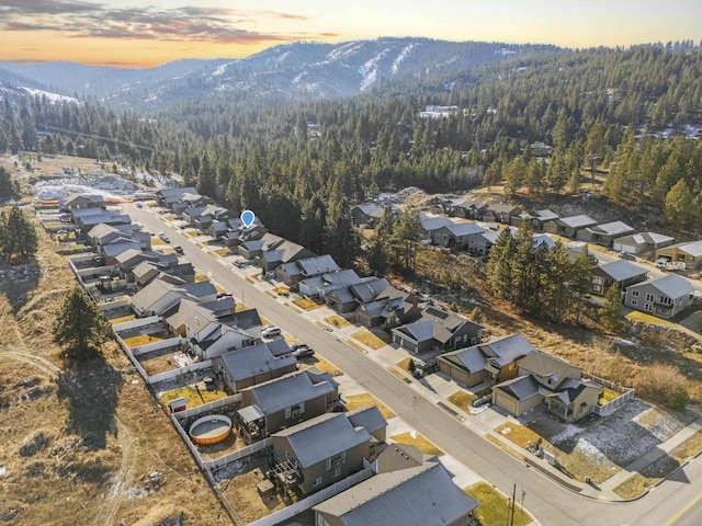 drone / aerial view featuring a residential view, a forest view, and a mountain view