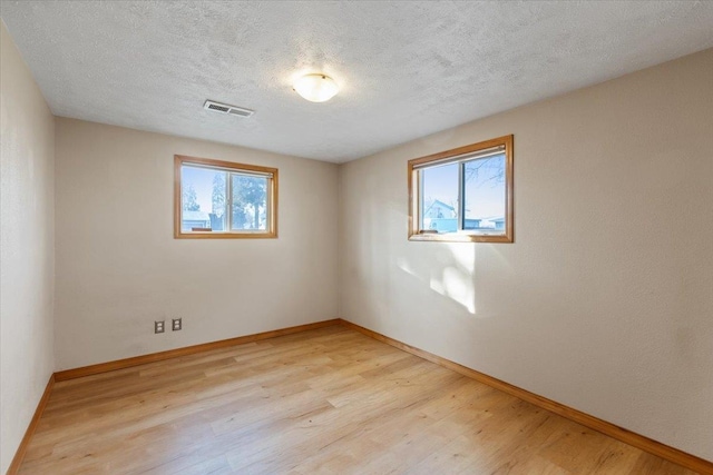 empty room featuring light hardwood / wood-style floors and a textured ceiling