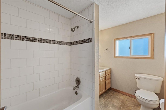 full bathroom featuring vanity, tiled shower / bath, a textured ceiling, and toilet