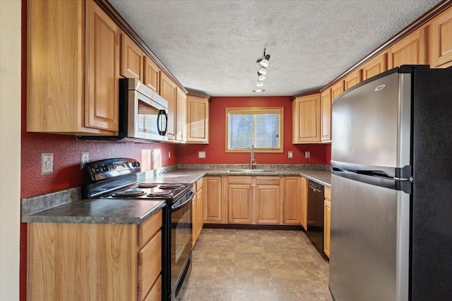 kitchen featuring rail lighting, sink, a textured ceiling, and black appliances