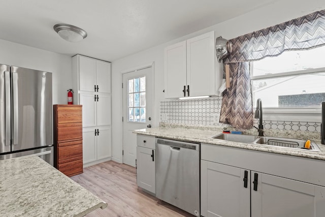 kitchen with white cabinetry, sink, backsplash, and appliances with stainless steel finishes