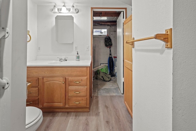 bathroom featuring vanity, wood-type flooring, and toilet