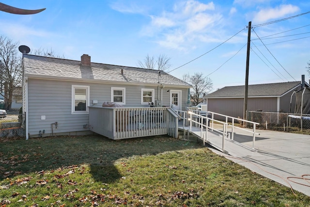 rear view of house featuring a yard and a deck