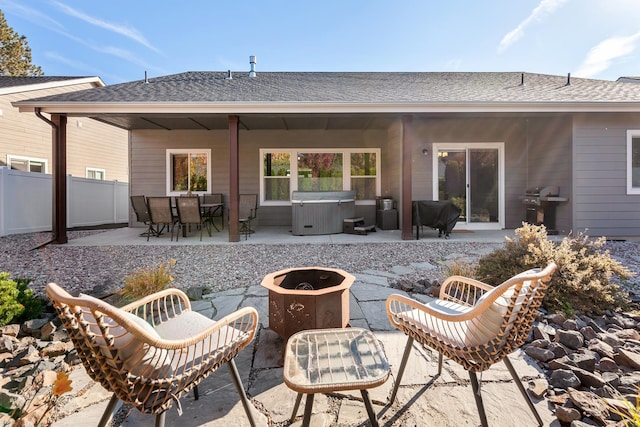 rear view of house featuring an outdoor fire pit, a hot tub, and a patio area