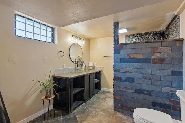 bathroom featuring vanity, a textured ceiling, and toilet