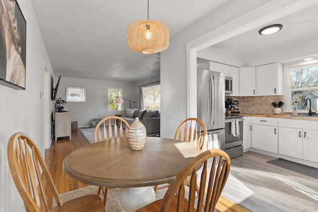 dining space with sink and light wood-type flooring