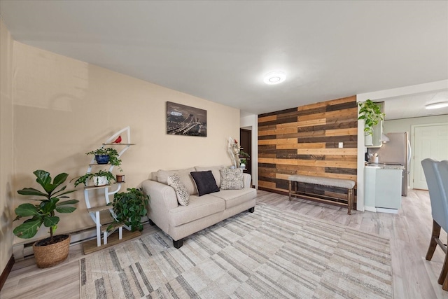 living room with light wood-type flooring and wood walls