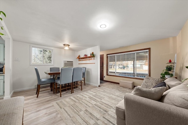 dining space featuring light hardwood / wood-style flooring and an AC wall unit