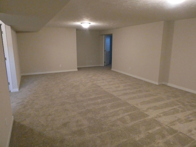 basement featuring light colored carpet and a textured ceiling