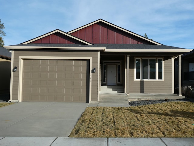 view of front of home with a garage, a front lawn, and covered porch