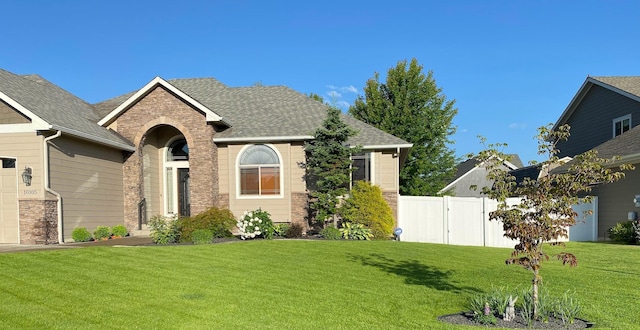 view of front of home featuring a front lawn, roof with shingles, and fence