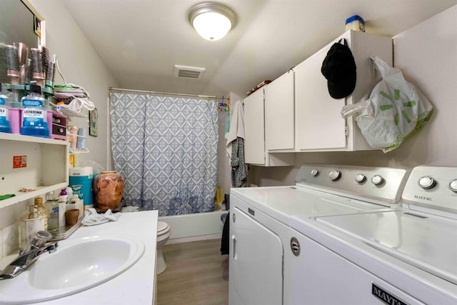 laundry room featuring sink, washing machine and clothes dryer, and light hardwood / wood-style floors