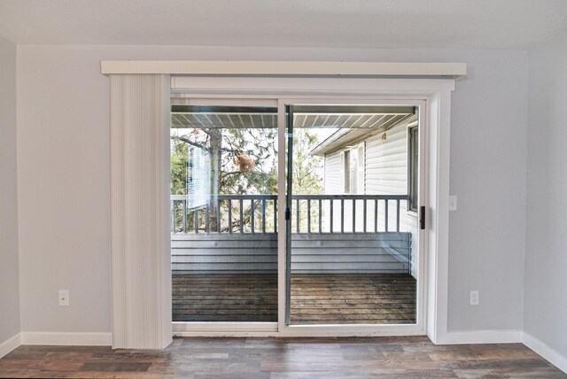 empty room featuring a baseboard radiator and dark hardwood / wood-style flooring