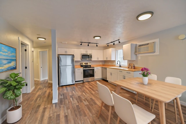 kitchen featuring appliances with stainless steel finishes, sink, white cabinets, and dark hardwood / wood-style floors