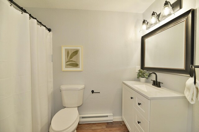 bathroom featuring baseboard heating, vanity, toilet, and wood-type flooring