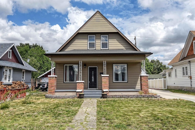 bungalow-style home with a front yard and covered porch