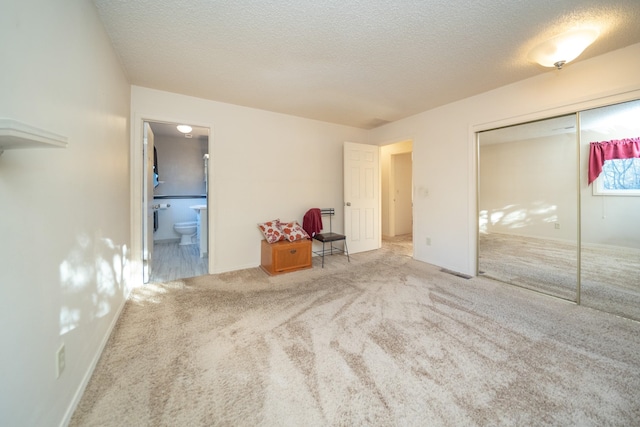 3732 E Westwood Ave, Chattaroy, WA 99003 - unfurnished bedroom featuring a closet, a textured ceiling, carpet, connected bathroom, and baseboards