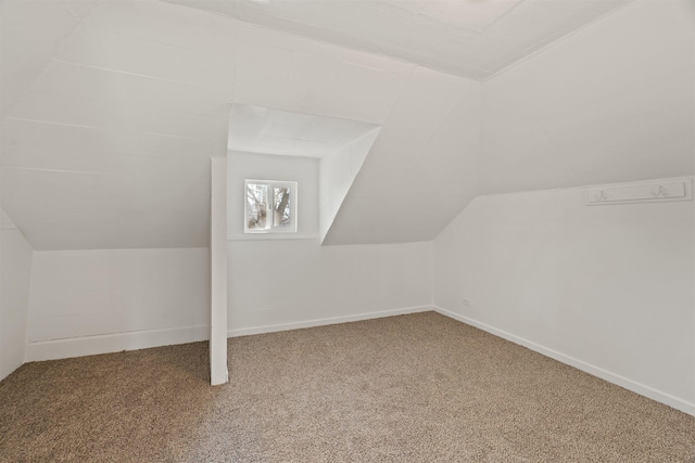 bonus room with vaulted ceiling and carpet flooring