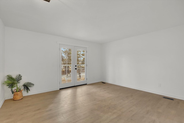 spare room with light hardwood / wood-style floors and french doors