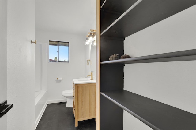 bathroom with concrete flooring, vanity, and toilet