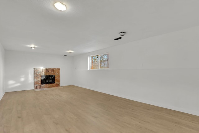 unfurnished living room with a fireplace and light hardwood / wood-style flooring