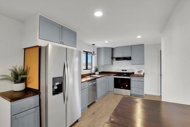 kitchen featuring sink, gray cabinets, hanging light fixtures, stainless steel appliances, and light hardwood / wood-style floors