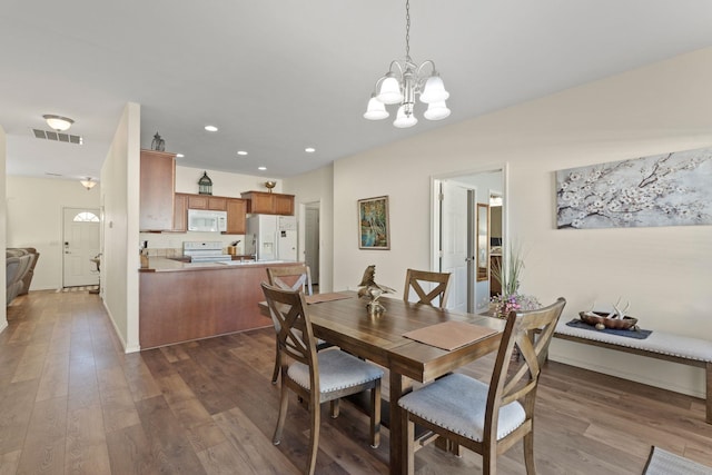 dining space with an inviting chandelier and dark wood-type flooring