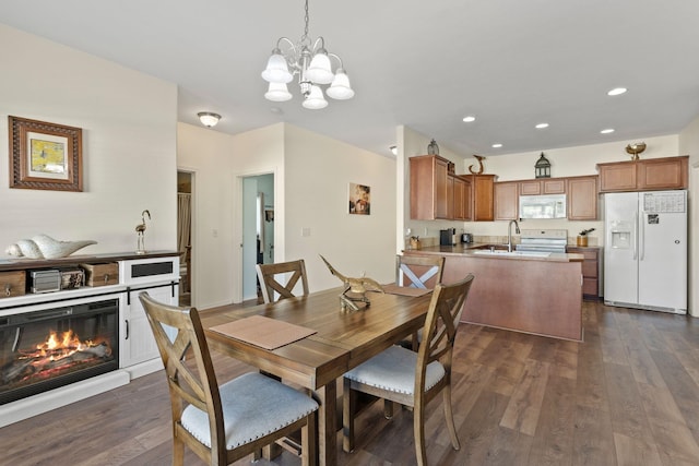 dining room featuring dark wood-type flooring, an inviting chandelier, and sink