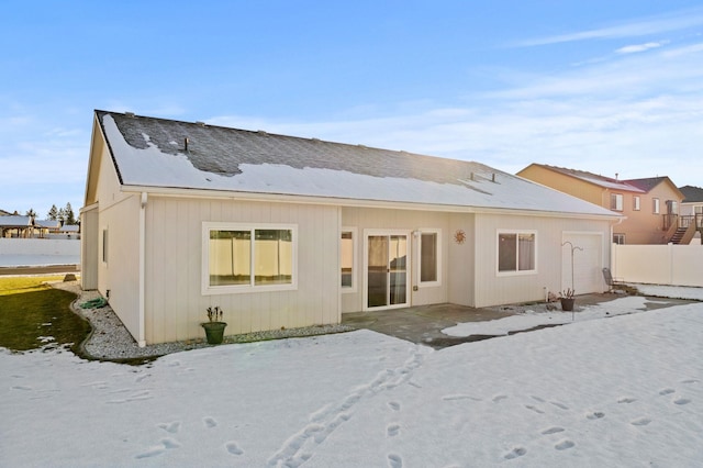 view of snow covered back of property